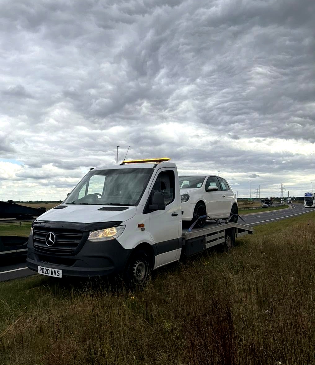 HC Recoverys flatbed carrying a car on the roadside