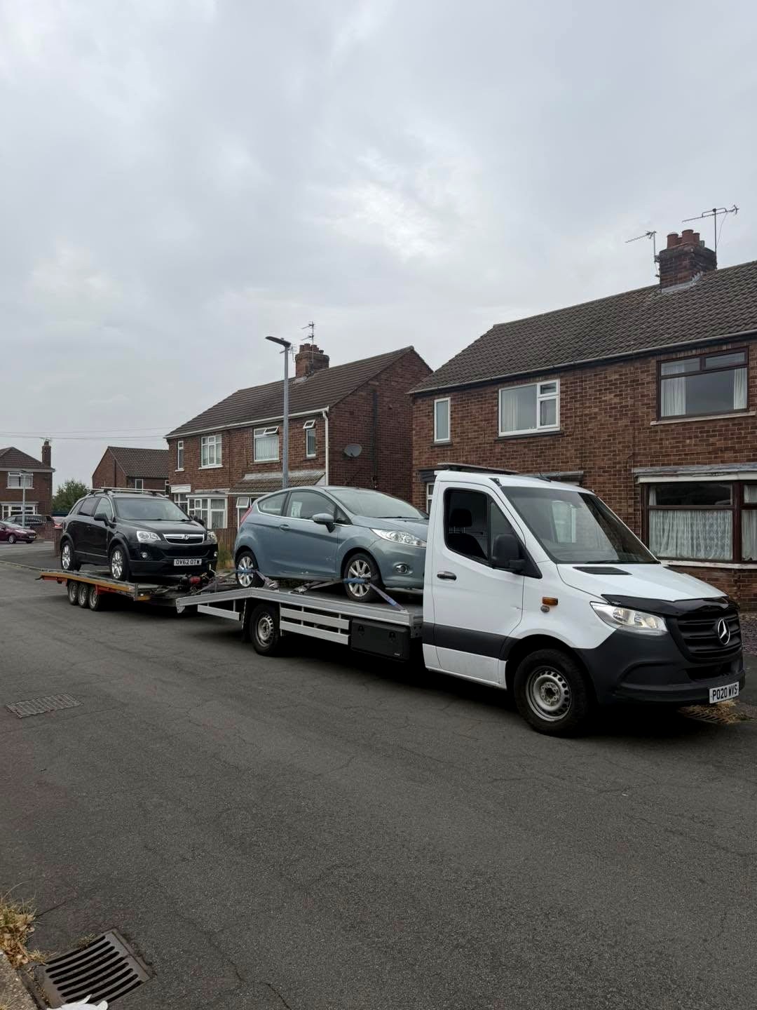Recovery truck carrying a Fiesta and towing a Vauxhall behind